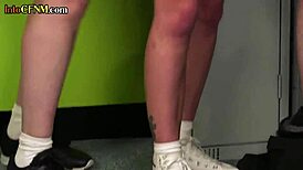 In the locker room, a European cheerleader gets a handjob from a femdom group while clothed.