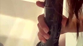 This white mature lady plays with a big black dildo at home