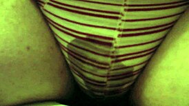 The girl pees in her red striped underpants on the toilet