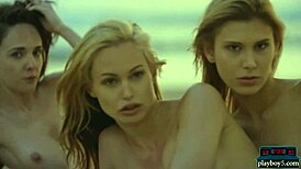 Four lesbian girlfriends strip and play with each other on a sunny beach.