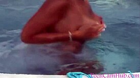 A young model teases with big tits by the pool in a bikini