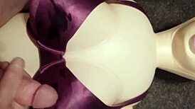 Dolly gives handjob in bra, ending with cumshot.