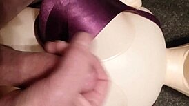 Dolly gives handjob in bra, ending with cumshot.