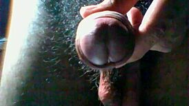 A detailed scene of hairy dick masturbation featuring a man stroking his thick, hairy cock in close-up view