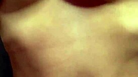 a student caresses her natural breasts at home