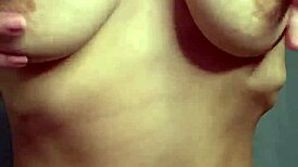 a student caresses her natural breasts at home