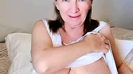 Horny granny wakes up, fingers her huge bust and slit