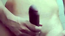 Hey, watch this shy guy masturbating his big cock in the bathroom