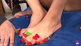 Kinky brunette using gummy bears for footjob fun