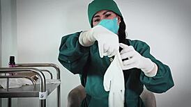 nurse in hospital uses latex gloves for fetish play